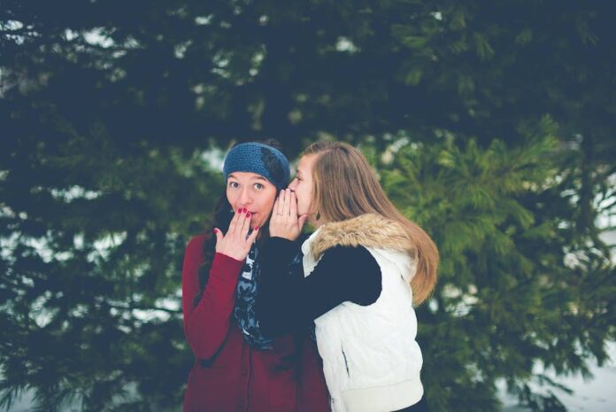 Two women whispering to each other