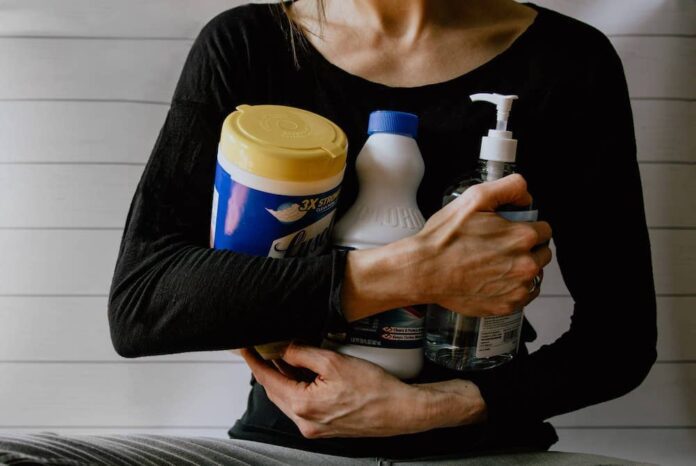 Woman carrying a variety of cleaning products