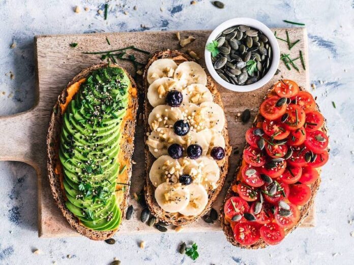 Three open faced toasts with avocado, bananas, and tomatoes