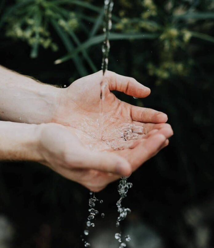 Hands underneath a stream of water