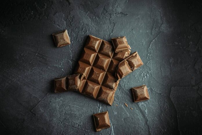 A broken chocolate bar on dark table