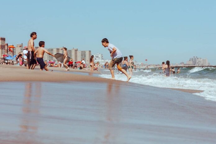 Kids running along the beach and water